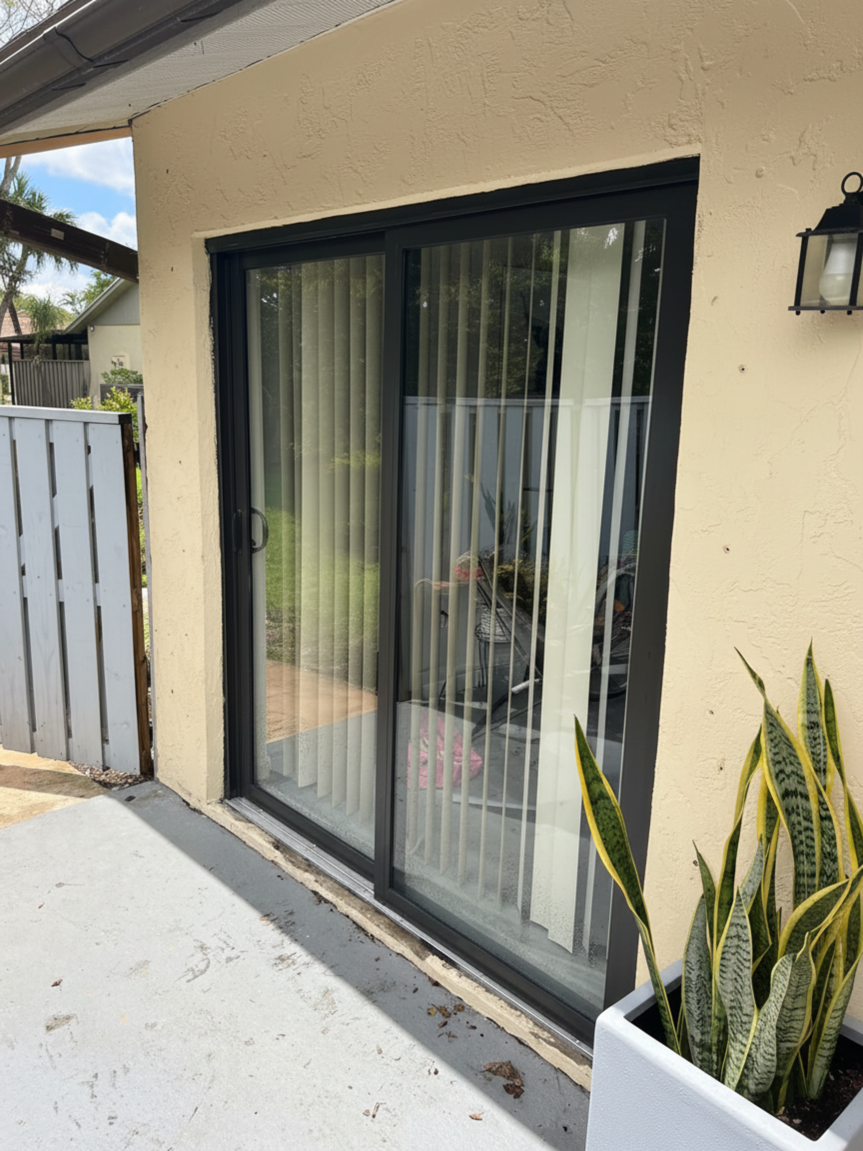 Modern dark-frame sliding glass impact door on a residential property
