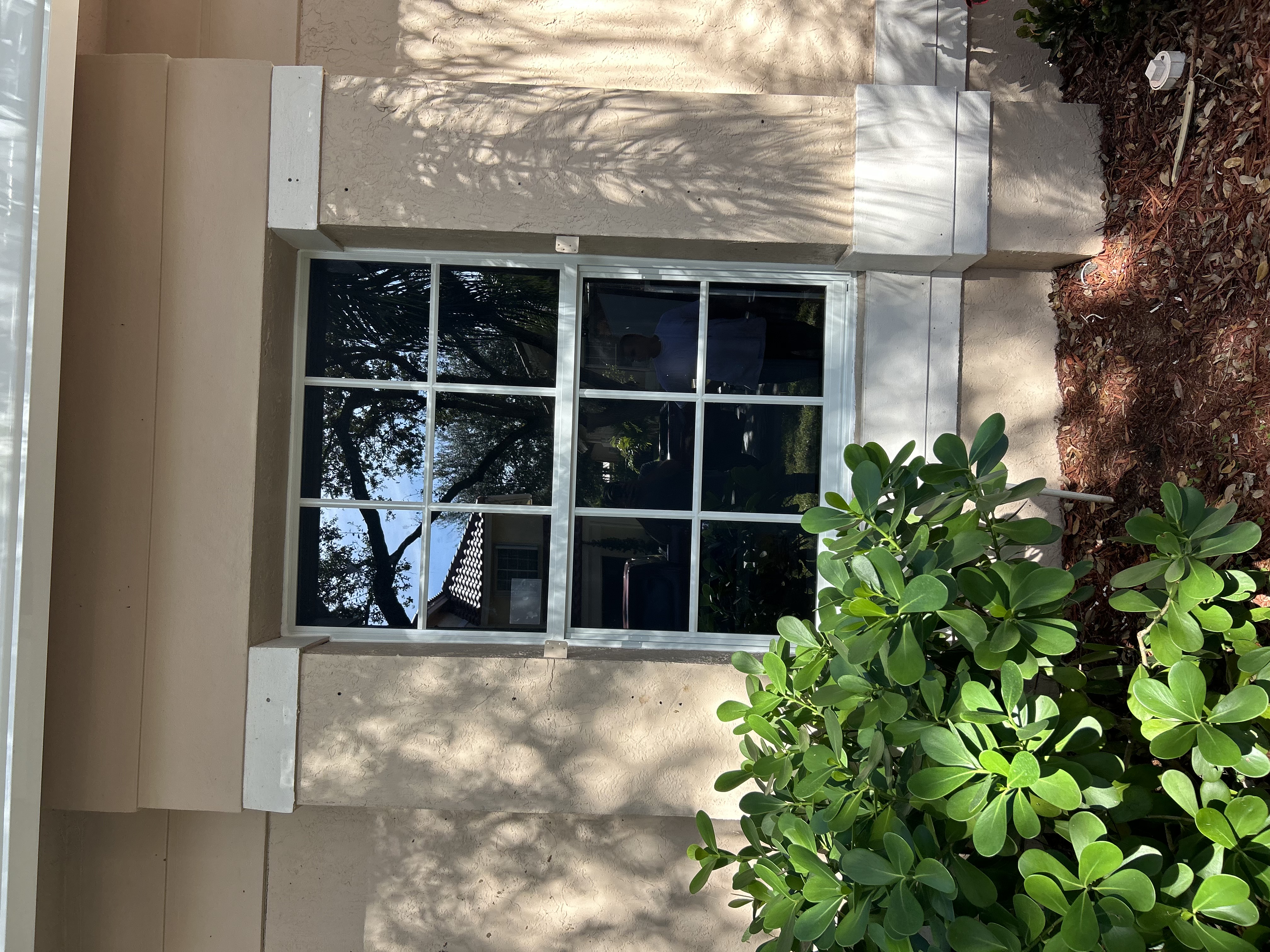 White colonial-style impact window installed on a South Florida home
